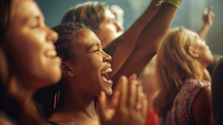 People in a crowd enjoying some form of live .width .jpg