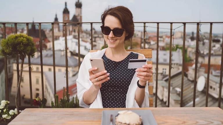 Woman holding her credit card and smiling whi.width iMSYz.jpg