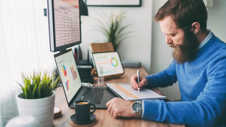 bearded person at desk by computer taking notes.jpg
