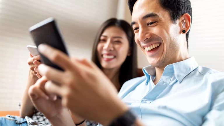 getty couple smiling at phone happy success.jpg