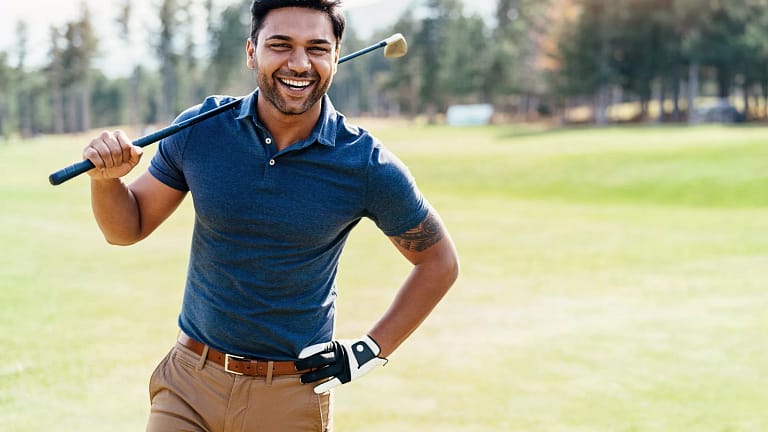 getty smiling golfer on course blue shirt.jpg