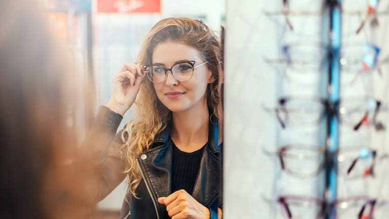 Smiling young woman trying on eyeglasses. dg.width .jpg