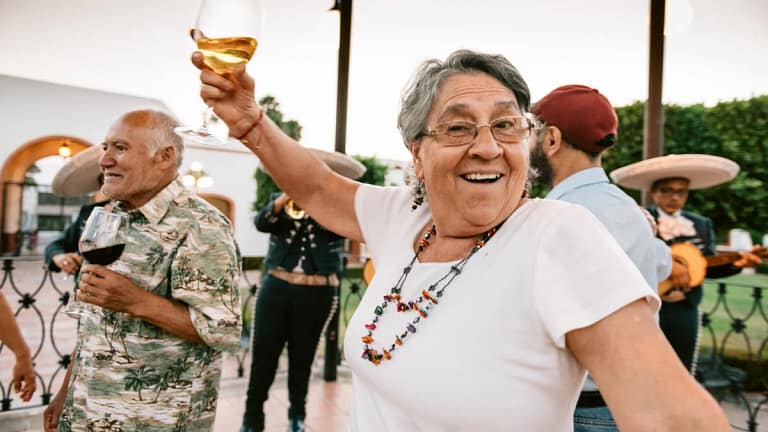 happy senior dancing and raising glass of wine.jpg