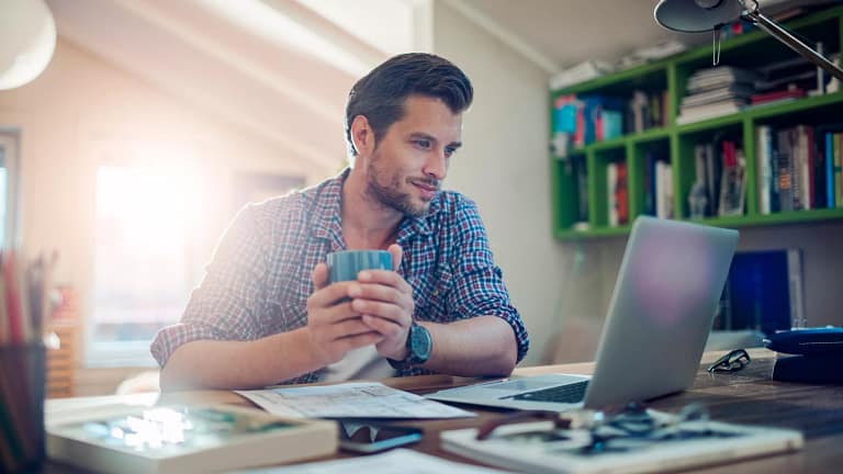 man s laptop holding mug gettyimages .jpg