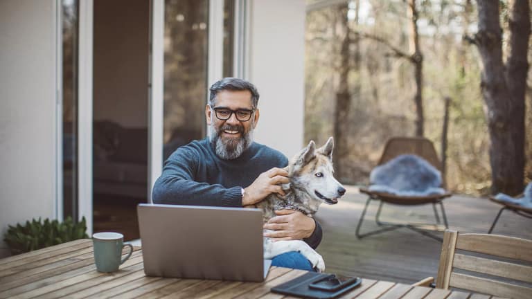 older man at laptop with dog gettyimages .jpg