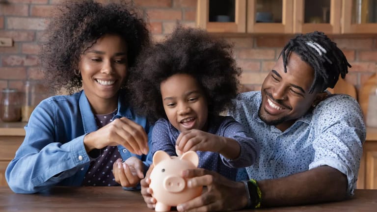 parents using a piggy bank to teach child about money.jpg