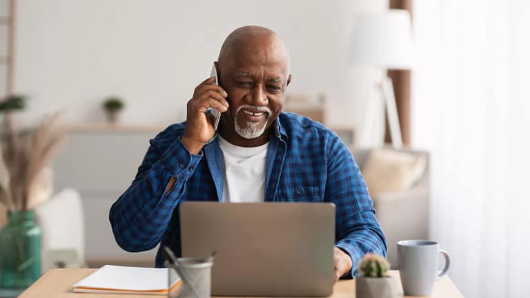 person talking on the phone and looking at a laptop.jpg
