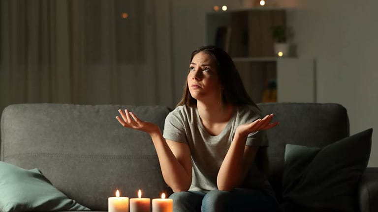person on couch with candles on coffee table .width .jpg