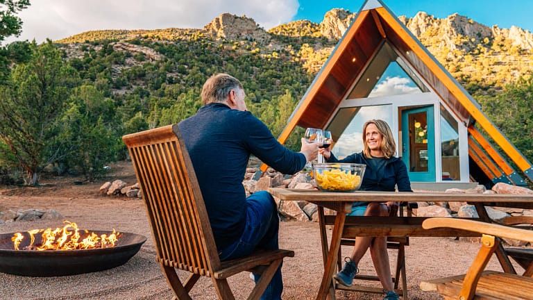 couple toasting over table outside house.jpg