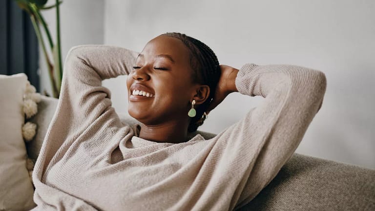 relaxed person sitting on couch with hands behind head.jpg