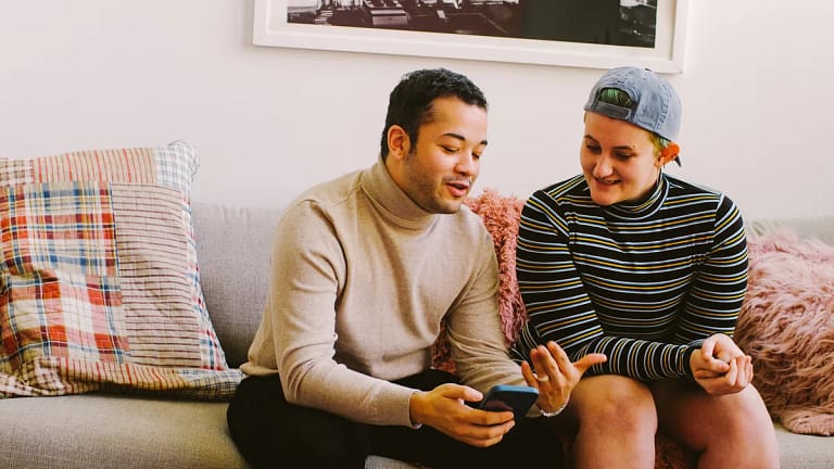 smiling couple discussing something on smartphone.jpg