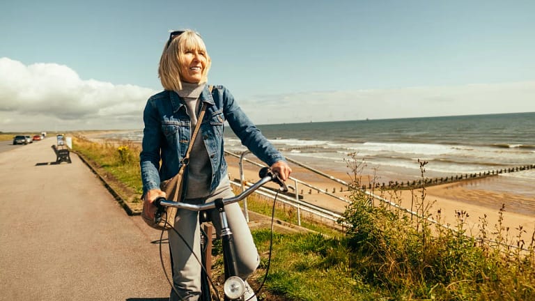 smiling person riding on bicycle by the ocean.jpg