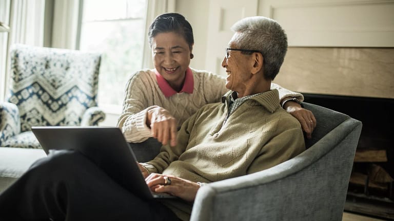 smiling senior couple using laptop at home.jpg