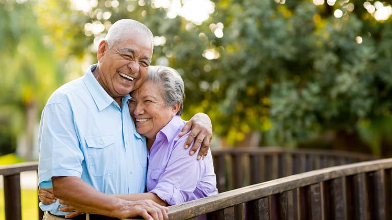 two older people standing outside hugging.jpg