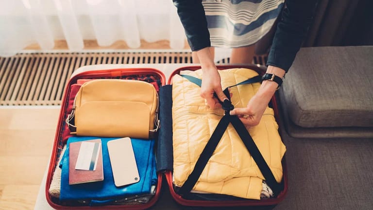 woman packing suitcase with credit card on to.width guLi.jpg