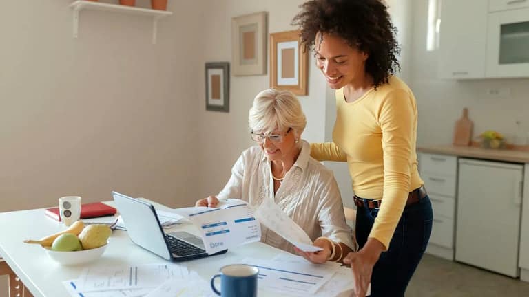 Two women look over finances in a kitchen nR.width .jpg